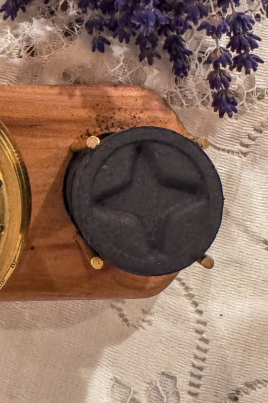 charcoal discs with star impression stacked on an incense burner tray