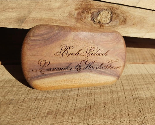 Wooden base for smoke cleansing kit engraved with cursive writing on the base.