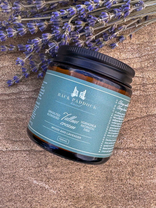 Jar of Back Paddock Tallow cream with lavender flowers on a textured surface